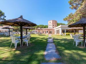 a patio with tables and chairs and umbrellas at Del Pinar Apart in Costa del Este