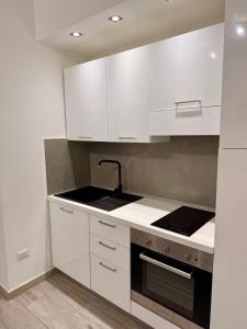 a kitchen with white cabinets and a sink at Casa Valentina in Tropea