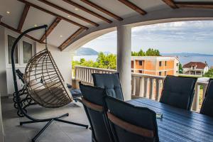 a porch with a swing and a table and chairs at Villa Angela in Orebić