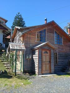 an old wooden house with a wooden door at Cabañas CyG 2 - Chaitén in Chaitén