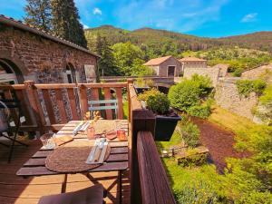 a wooden deck with a picnic table on a balcony at Auberge de Chanteuges in Chanteuges