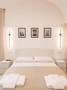 a white bedroom with a large bed with towels on it at Casa Corallium in Torre del Greco