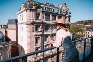 a woman standing on a balcony in front of a building at Radisson Blu Hotel, Rouen Centre in Rouen