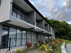 a building with a balcony with flowers on the side at My Way Village & Spa in Çayqovuşan