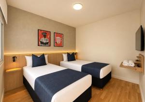 a hotel room with two beds and a tv at Los Patios de Julia by DOT Boutique in Buenos Aires +19 photos