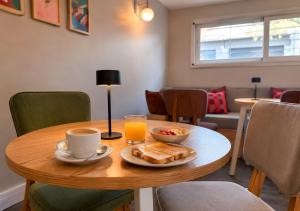 a table with a plate of food and a cup of orange juice at Los Patios de Julia by DOT Boutique in Buenos Aires