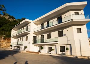 a white building with balconies on a street at Dine Residence in Himare