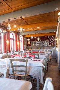 a dining room with white tables and chairs at Albergo La Veranda in Tavarone