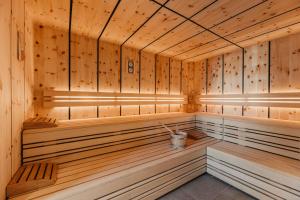 a sauna with wooden walls and benches in a room at NaturResidence Dolomitenhof in Siusi