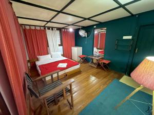a bedroom with a bed and a table in a room at Whispering Willows in Gūdalūr