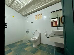 a bathroom with a toilet and a sink at Whispering Willows in Gūdalūr +79 photos