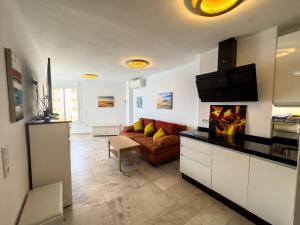 a living room with a couch and a tv at Increíbles vistas al mar A102 in Torrox Costa