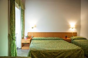 a hotel room with two beds and a window at Albergo La Veranda in Tavarone