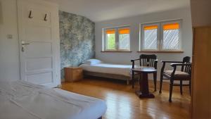 a bedroom with a bed and a table and chairs at Domki Magda Rewal in Rewal