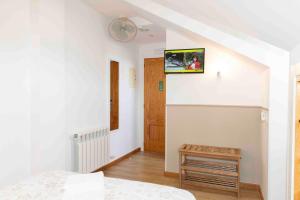 a bedroom with a bed and a tv on the wall at Hotel San Briz in A Pontenova