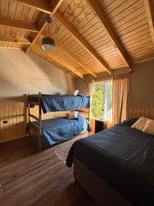 a bedroom with two bunk beds and a window at Cabañas Lago Huillinco in Chonchi