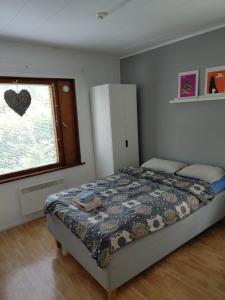 a bedroom with a bed in front of a window at Wooden House 2 bedrooms in Turku