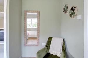 a mirror and a green chair in a room at Greenfields Apartment in Chester