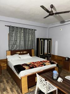 a bedroom with a large bed with a ceiling fan at Parma Guest House in Kasol