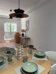 a dining room with a table with plates and wine glasses at Oasis de César- Arquitectura Manriqueña in Costa Teguise