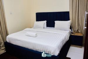 a large bed with white sheets and pillows on it at Skyline Exquisite in Araromi