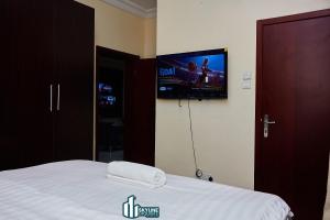 a bedroom with a bed with a tv on the wall at Skyline Exquisite in Araromi +1 photo