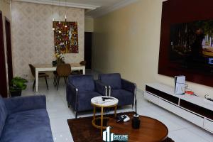 a living room with two blue chairs and a tv at Skyline Exquisite in Araromi
