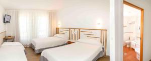 a hotel room with two beds and a bathroom at Hotel San Briz in A Pontenova