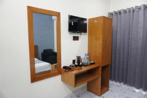 a mirror in a room with a room with a bed at Hotel Comfort Inn Sylhet in Sylhet