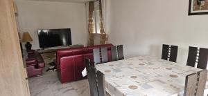 a dining room with a table and a television at Elsa in Pontivy