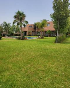 a large yard with a building in the background at Villa Serenity MARRAKECH in Oulad Mazoug