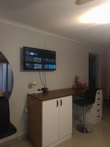 a room with a desk and a tv on the wall at Siyapeya Household in Bellville