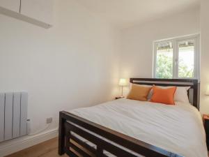 a bedroom with a large bed with orange pillows at Rollies Retreat in Fowey