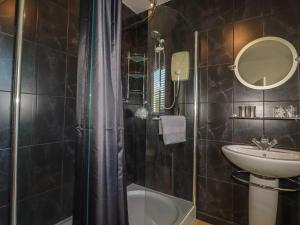 a bathroom with a shower and a sink and a tub at Rollies Retreat in Fowey +10 photos