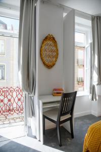 a bedroom with a desk and a chair next to a window at Lisbon Poets Inn in Lisbon