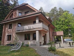 a house with a balcony and a table and chairs at ChataKováčová in Kováčová