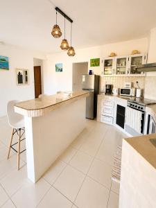 a kitchen with white cabinets and a large island at Pointe D'Esny Villa 1 in Mahébourg