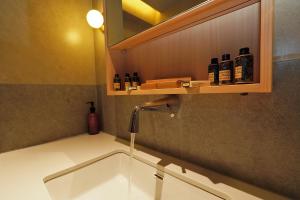 a kitchen sink with a faucet and some bottles at Ionian Crown Suites in Barbati in Barbati +23 photos