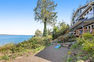 a house on a hill next to the water at Olympus View Home in Port Ludlow
