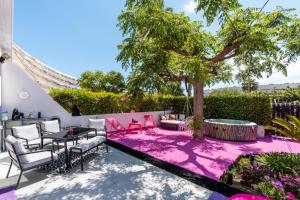 a patio with a table and chairs and a tree at Villa L'Hyliadenna avec jardin - parking privé - au cœur du Village Naturiste, NaturaBeach Héliopolis - Plage à pied in Cap d'Agde +23 photos