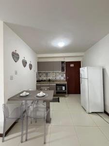 a kitchen with a table and a refrigerator at Villas do Pratagy Bambu 2 in Maceió
