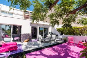 a house with a purple rug in the yard at Villa L'Hyliadenna avec jardin - parking privé - au cœur du Village Naturiste, NaturaBeach Héliopolis - Plage à pied in Cap d'Agde