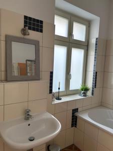 a bathroom with a sink and a mirror at Familienhaus Stadtmitte in Neustrelitz +24 photos