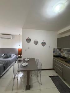 a room with a bed and a table and a kitchen at Villas do Pratagy Bambu 2 in Maceió