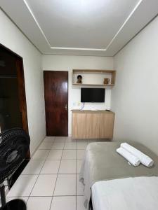 a bedroom with a bed and a flat screen tv at Hotel Piracema in Caruaru