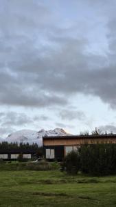 a building in a field with a mountain in the background at Casa Vulkaan in Puerto Varas +31 photos