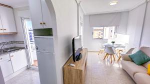 a living room with a couch and a kitchen with a table at Apartamento Luz de Almoradi in Almoradí