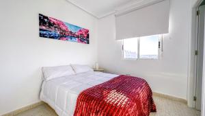 a white bedroom with a bed and two windows at Apartamento Luz de Almoradi in Almoradí +25 photos