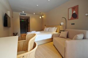 a hotel room with a bed and a couch at Ionian Crown Suites in Barbati in Barbati