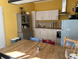 a kitchen with a wooden table and a refrigerator at Familienhaus Stadtmitte in Neustrelitz
